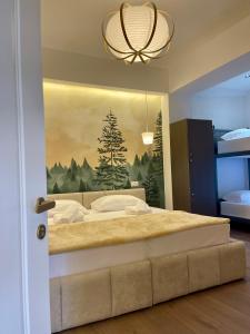a bedroom with a large bed with a painting on the wall at Bora Hotel in Gjirokastër