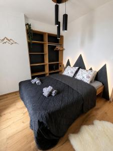 a bedroom with a large bed with black sheets and pillows at Apartmán 18 Lidická bouda in Pec pod Sněžkou