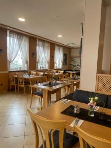 a restaurant with wooden tables and chairs and windows at Gasthof Kirchberger in Fürth