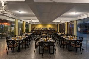 a restaurant with tables and chairs in a room at Con Nho RiverHouse Hue in Thôn Tiên Nộn