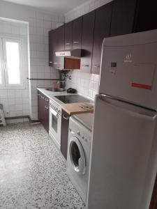 a kitchen with a washing machine and a refrigerator at Donato in Gijón
