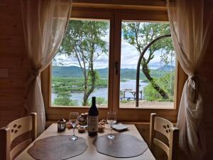 a table with a bottle of wine and a window at Lake house Andrej & Andrea in Kuside