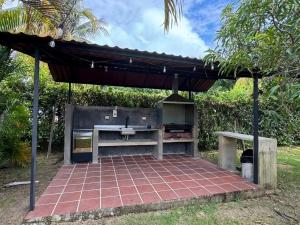 a barbecue under a pergola with a sink at Casa 007 in Carmen de Apicalá +14 photos