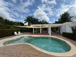 a swimming pool in front of a house at Casa 007 in Carmen de Apicalá