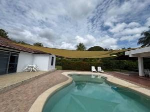 a swimming pool with a canopy over a house at Casa 007 in Carmen de Apicalá