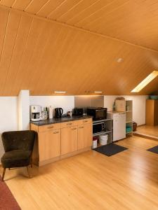 a large kitchen with wooden cabinets and a chair in a room at Monteurzimmer-Graf in Nidda