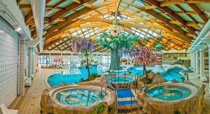 a large swimming pool with two hot tubs in a building at Jack House in Mostec