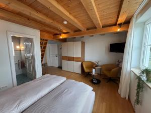 a bedroom with a bed and a television in a room at Landhaus am Bach in Sulzberg