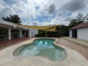 a swimming pool in front of a house at Casa 007 in Carmen de Apicalá