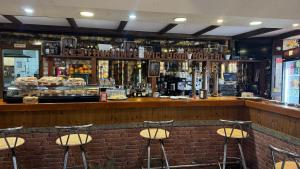 a bar with five bar stools in front of it at Hosteria Conchi in Madrigal de la Vera +10 photos