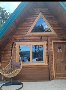 a wicker chair in front of a building with a window at Lake house Andrej & Andrea in Kuside +5 photos