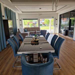 a dining room with a table and blue chairs at Villa Breza in Bihać