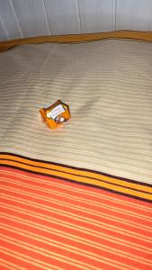 a bed with an orange package on top of it at Hüller Ferienwohnung in Gräfenberg