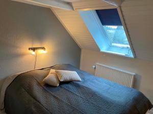 a bedroom with a bed with two pillows on it at Private country side apartment in Holstebro