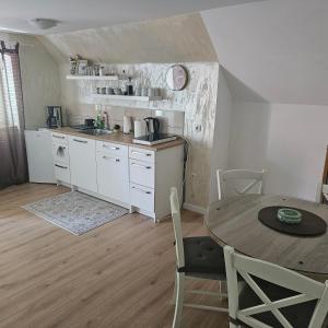 a kitchen with a table and a dining room at Apartman Čardak in Gospić
