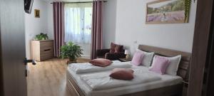 a bedroom with two beds with pink and white pillows at Casa Maria in Avrig