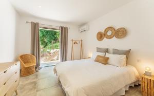 a bedroom with a large bed and a balcony at Le Cabanon de Val in Gassin