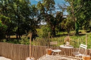 a patio with a table and chairs and a fence at Le Cabanon de Val in Gassin