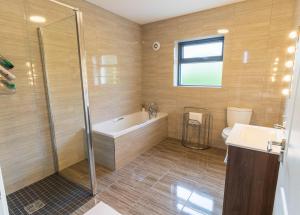 a bathroom with a tub and a shower and a toilet at Carhan House - Cahersiveen in Cahersiveen +7 photos