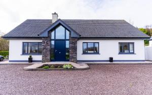 a white house with a blue door at Carhan House - Cahersiveen in Cahersiveen