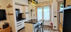a kitchen with a counter and chairs in a room at Mini loft moderno di fronte Zoomarine in Torvaianica