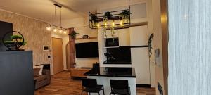 a living room with a kitchen with a counter and chairs at Mini loft moderno di fronte Zoomarine in Torvaianica