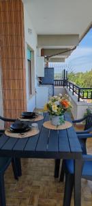 a blue table with a vase of flowers on a balcony at Mini loft moderno di fronte Zoomarine in Torvaianica +8 photos