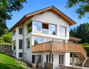 a white house with a wooden roof at Das Mondsee-Retreat in Innerschwand