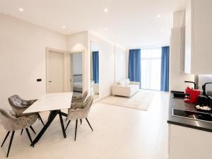 a kitchen and living room with a table and chairs at Bellemond Hotel & Residences in Budva