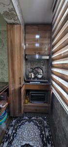 a small kitchen with a stove and a microwave at Ganja Apart in Ganja