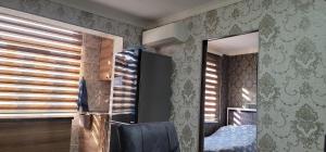 a room with a refrigerator and a mirror at Ganja Apart in Ganja