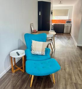 a living room with a blue chair and a table at Sea Breeze with City Ease in Port Lincoln +8 photos