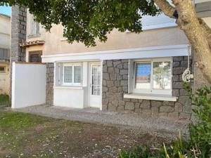 a house with two windows and a stone wall at À 100m de l ocean in Longeville-sur-Mer