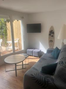 a living room with a couch and a table at À 100m de l ocean in Longeville-sur-Mer