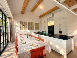 a kitchen with a long table with chairs and a counter at Mas Guerite - Provence in Aubignan