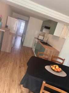 a kitchen with a table with a bowl of fruit on it at À 100m de l ocean in Longeville-sur-Mer