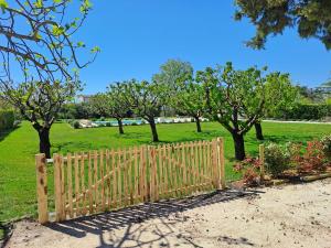 a wooden fence in a park with trees and grass at Mas Guerite - Provence in Aubignan