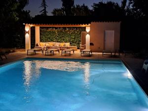 a large swimming pool with a table and a couch at Mas Guerite - Provence in Aubignan