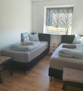 a bedroom with two beds and a window at Fælleshuset Kirkebakken in Otterup