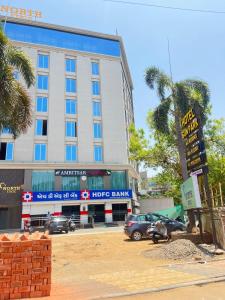 a large building with cars parked in a parking lot at Hotel Sun Park Vadodara in Vadodara