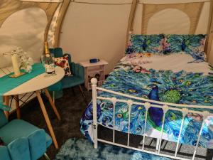 a bedroom with a bed and a table and chairs at The Shire Glamping in Kearsney +32 photos