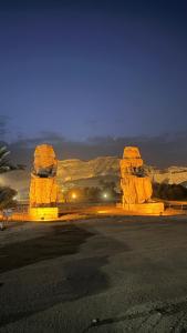 a group of large stoneoliths in a desert at night at Jessica's House in Luxor