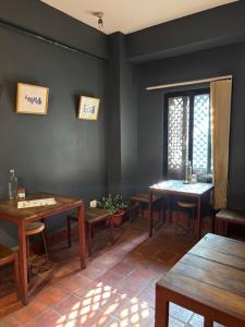 a dining room with wooden tables and a window at Davu Gallery Cafe in Kathmandu