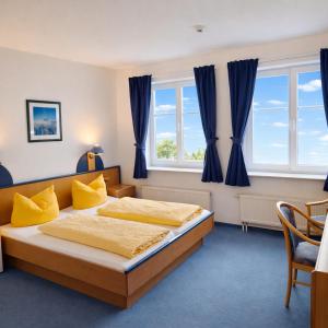 a bedroom with two beds and a window at Sporthotel Middelpunkt in Aurich