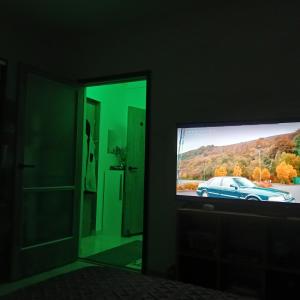 a television in a room with a car on the screen at Zöld otthon in Szeged