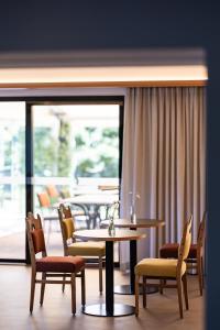 a dining room with tables and chairs and a large window at JOHAN - Rooms & Breakfast Merano in Marlengo