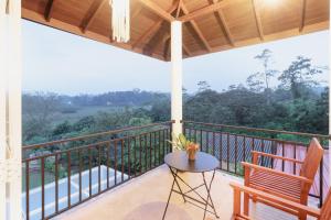 a balcony with a table and chairs and a view at Ayurishi Villa in Hikkaduwa