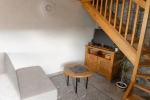 a living room with a couch and a tv and a stool at Casa Saudade Vila Real North in Vila Real