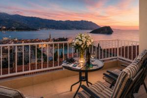 a balcony with a table and chairs with a view of the ocean at Apartments Inspiration in Budva