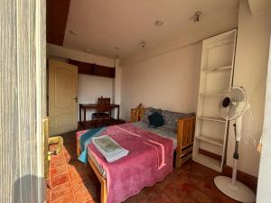 a bedroom with a bed and a fan in it at Tehra Family Building in Kathmandu